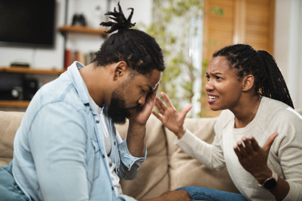 Angry African American couple arguing on sofa in the living room